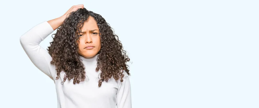 Woman with curly hair scratching her scalp